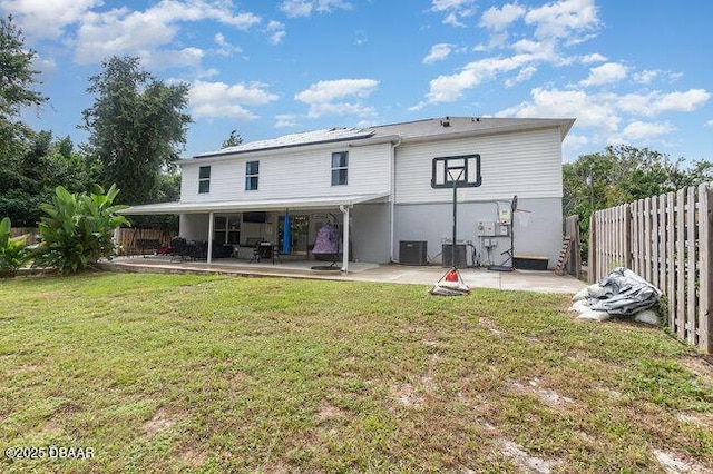 rear view of property featuring a yard, a patio, and central air condition unit