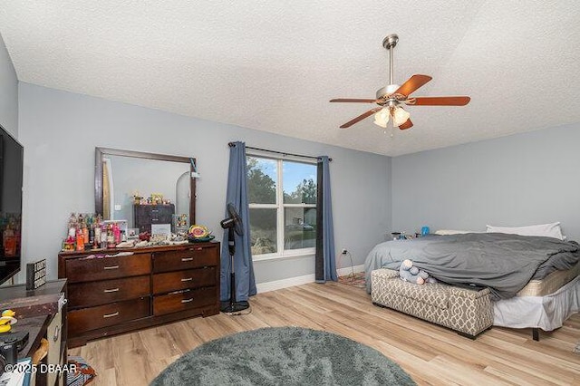 bedroom featuring a textured ceiling, light hardwood / wood-style floors, and ceiling fan