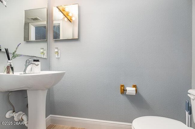 bathroom featuring hardwood / wood-style floors and toilet