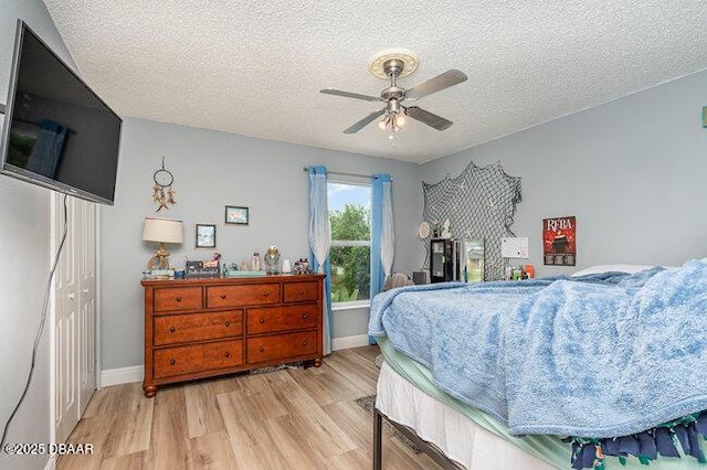 bedroom featuring ceiling fan, a closet, a textured ceiling, and light wood-type flooring