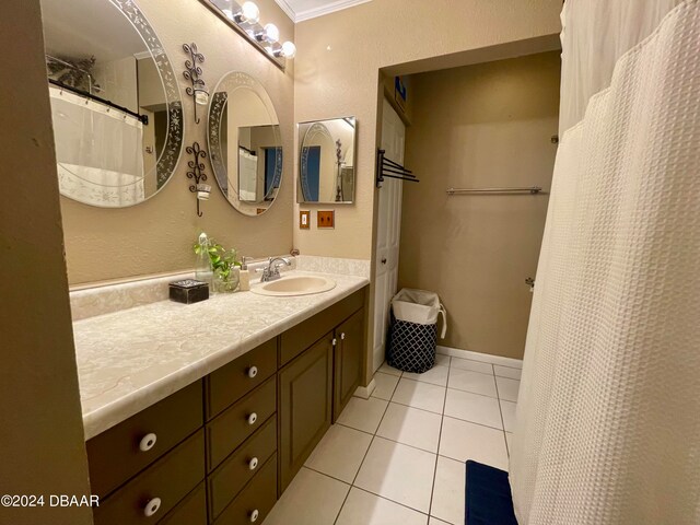 bathroom featuring tile patterned flooring, vanity, and crown molding