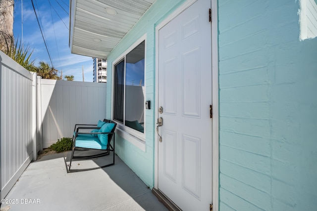 property entrance with concrete block siding and fence