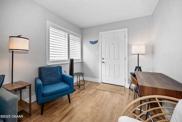 sitting room with light wood-type flooring and baseboards