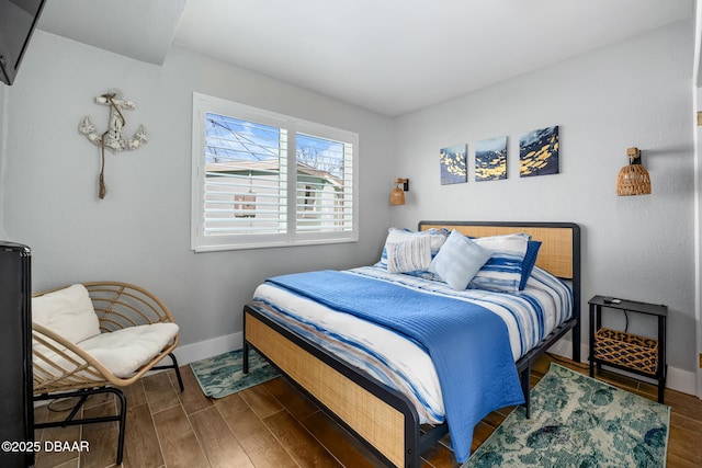 bedroom with baseboards and wood finished floors