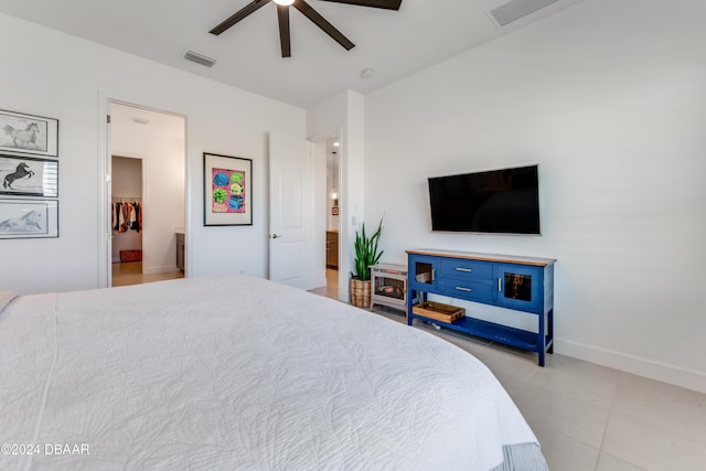 bedroom with ceiling fan, light tile patterned floors, and a spacious closet