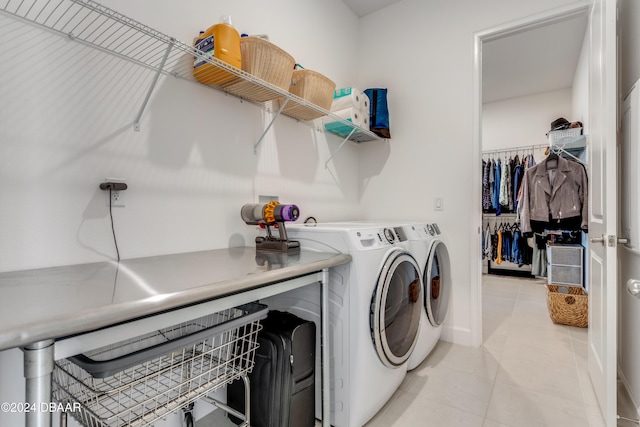 laundry area with washer and clothes dryer and light tile patterned floors