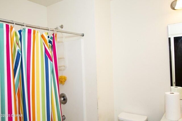 full bathroom with toilet and a shower with curtain