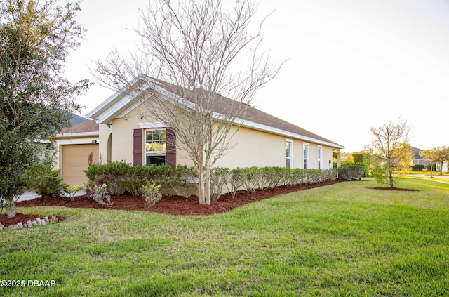 view of property exterior with a yard, an attached garage, and stucco siding