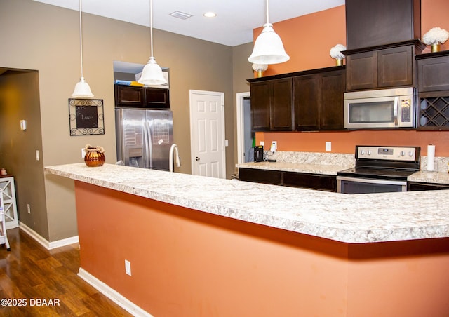 kitchen with dark brown cabinetry, visible vents, appliances with stainless steel finishes, dark wood-type flooring, and light countertops