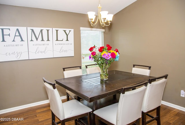 dining room with dark wood-type flooring, a notable chandelier, and baseboards