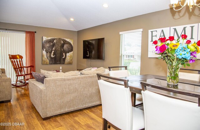 living room featuring a chandelier, recessed lighting, vaulted ceiling, and wood finished floors