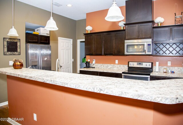 kitchen with visible vents, stainless steel appliances, dark brown cabinets, and light countertops