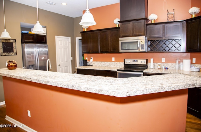 kitchen with dark brown cabinetry, visible vents, appliances with stainless steel finishes, dark wood-type flooring, and light countertops