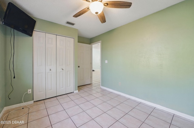 10 Lake Forest Cir N, Palm Coast, FL 32137 - unfurnished bedroom with ceiling fan, a closet, visible vents, light tile patterned flooring, and baseboards