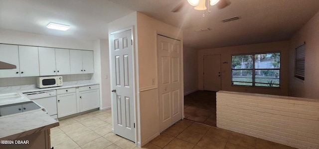 kitchen with white cabinetry, ceiling fan, white appliances, decorative backsplash, and light tile patterned floors