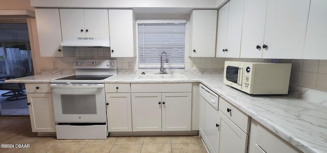 kitchen with white cabinetry, sink, tasteful backsplash, white appliances, and light tile patterned floors