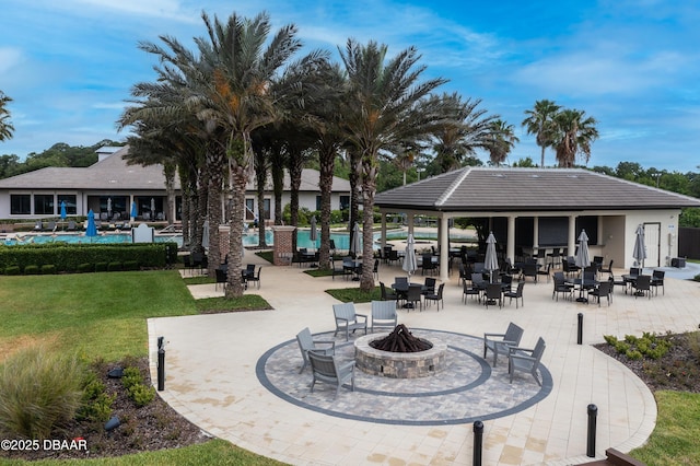 exterior space featuring a lawn, a swimming pool, a fire pit, and a patio