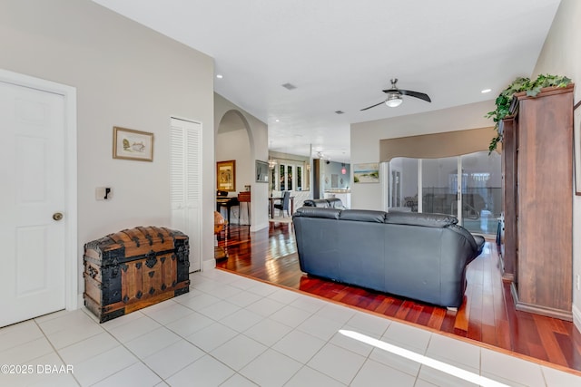 living area featuring a ceiling fan, arched walkways, recessed lighting, and tile patterned flooring