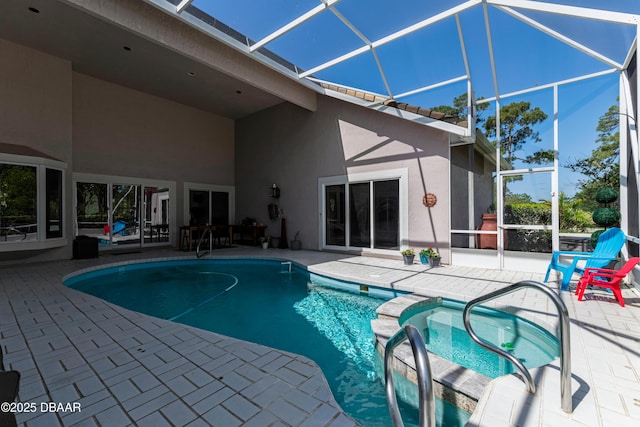 view of pool featuring a patio, a pool with connected hot tub, and glass enclosure
