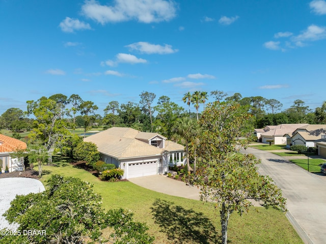 view of front of home featuring concrete driveway, a tile roof, a front yard, and a garage