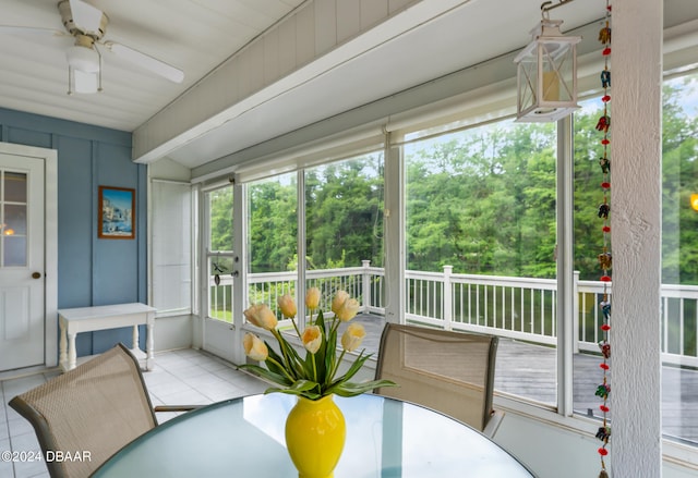 sunroom featuring beamed ceiling, ceiling fan, and plenty of natural light