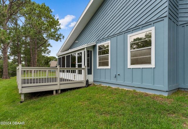 view of side of home featuring a wooden deck and a lawn