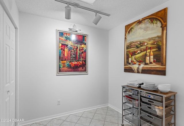 dining area with a textured ceiling and light tile patterned flooring