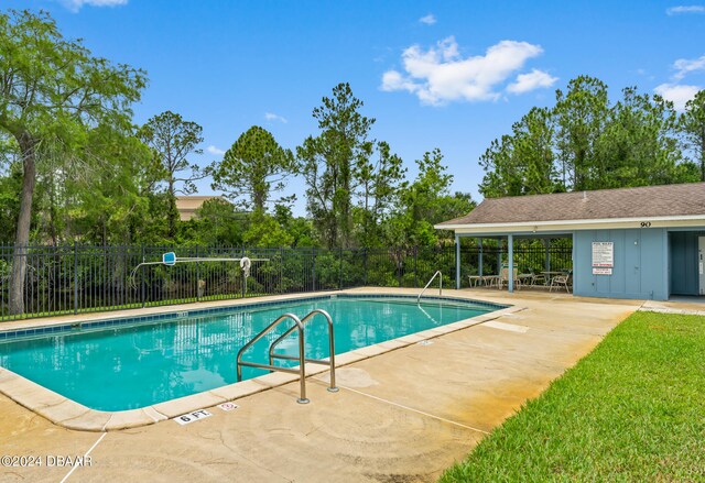 view of swimming pool with a patio and a yard