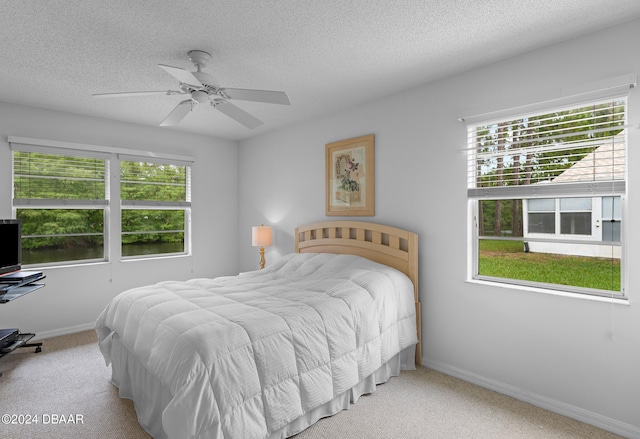 bedroom featuring multiple windows, light carpet, and ceiling fan