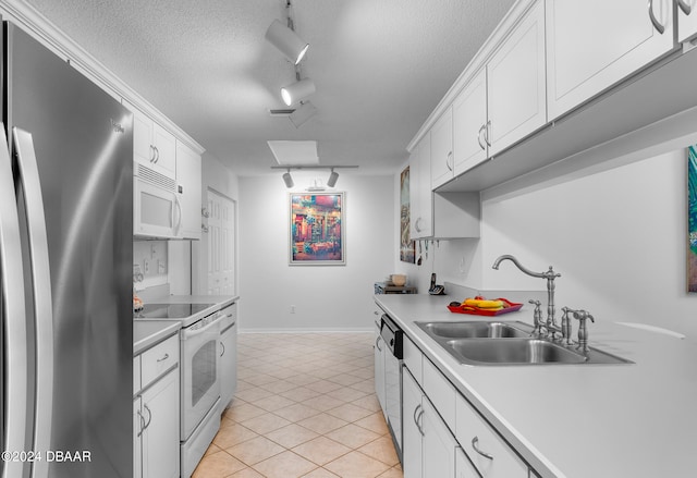 kitchen with white cabinets, a textured ceiling, sink, light tile patterned flooring, and appliances with stainless steel finishes