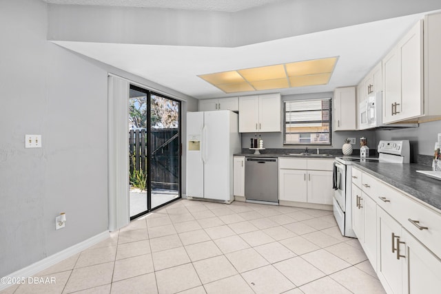 kitchen featuring white cabinetry, sink, white appliances, and light tile patterned floors