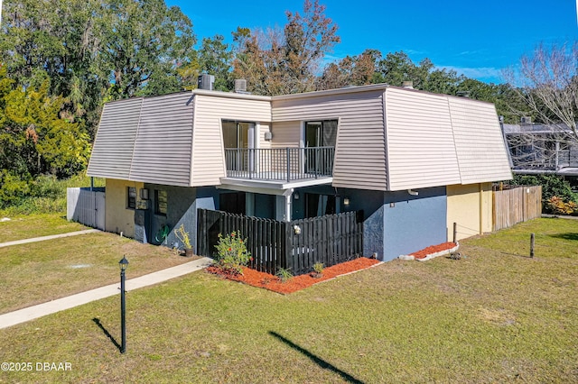 exterior space featuring a balcony and a front yard