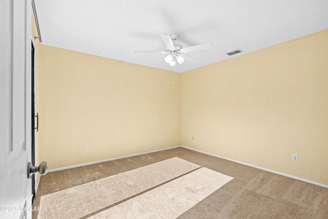 carpeted spare room with ceiling fan