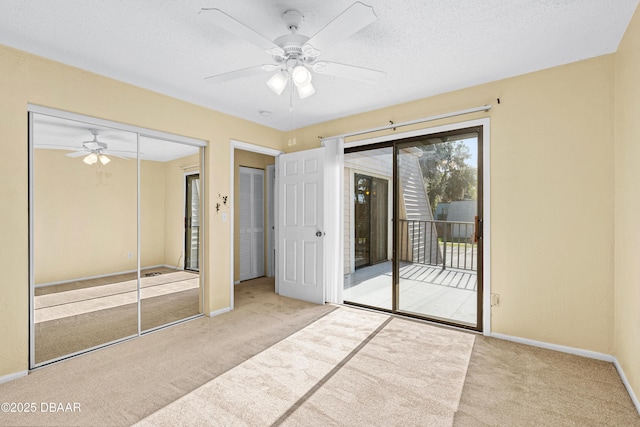 unfurnished bedroom with a textured ceiling, light carpet, a closet, and access to outside