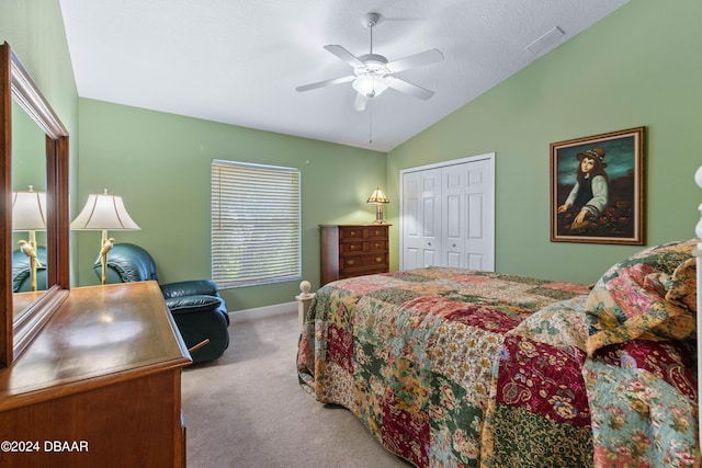 bedroom with light colored carpet, lofted ceiling, a textured ceiling, ceiling fan, and a closet