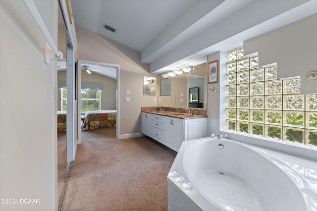 bathroom with a washtub, vanity, ceiling fan, and vaulted ceiling