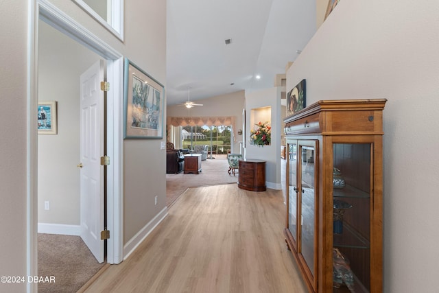 corridor featuring light hardwood / wood-style floors and lofted ceiling