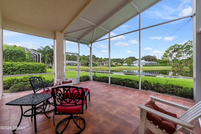 sunroom featuring a water view and vaulted ceiling