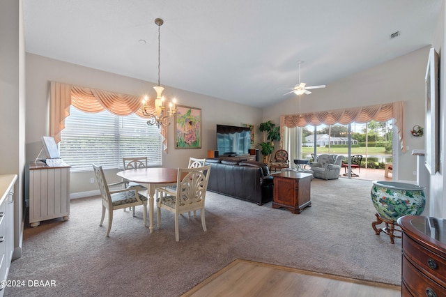 dining room with light hardwood / wood-style floors, ceiling fan with notable chandelier, and lofted ceiling