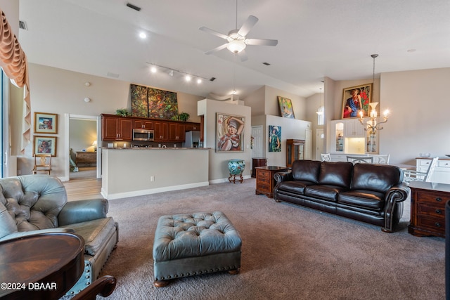 living room featuring ceiling fan with notable chandelier, rail lighting, and light carpet