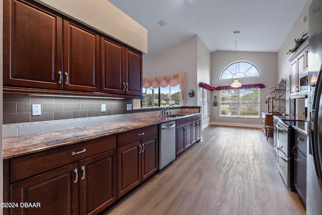 kitchen featuring sink, appliances with stainless steel finishes, decorative light fixtures, light wood-type flooring, and decorative backsplash