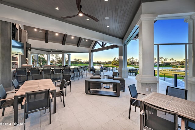 exterior space with lofted ceiling with beams, wood ceiling, decorative columns, a water view, and ceiling fan