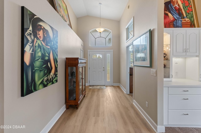 doorway with light hardwood / wood-style flooring and lofted ceiling