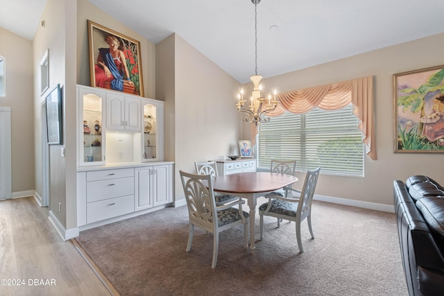 dining area featuring vaulted ceiling, a notable chandelier, and light hardwood / wood-style floors