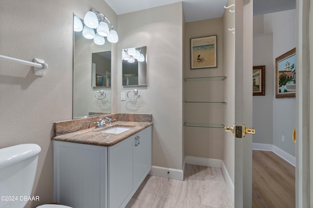 bathroom featuring wood-type flooring, vanity, and toilet