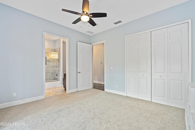 unfurnished bedroom with ensuite bath, ceiling fan, a closet, and light colored carpet