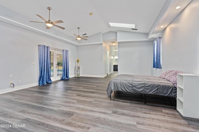 bedroom with access to exterior, wood-type flooring, lofted ceiling with skylight, and ceiling fan