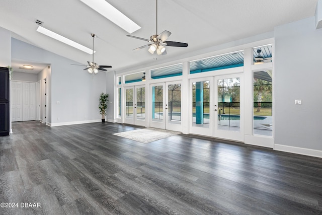 unfurnished living room featuring french doors, dark hardwood / wood-style flooring, lofted ceiling with skylight, and ceiling fan