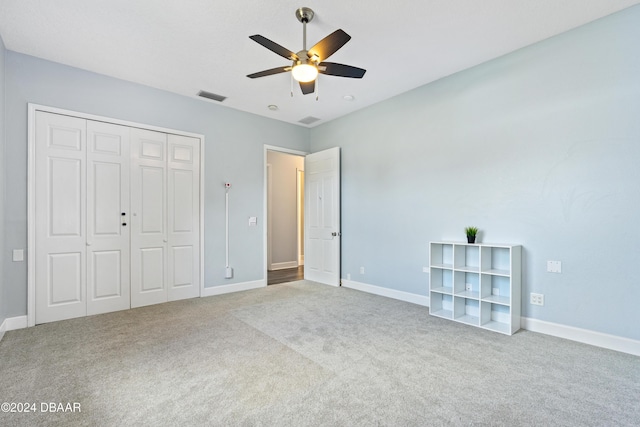 unfurnished bedroom featuring carpet, ceiling fan, and a closet