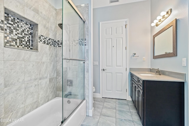 full bathroom featuring vanity, toilet, and bath / shower combo with glass door